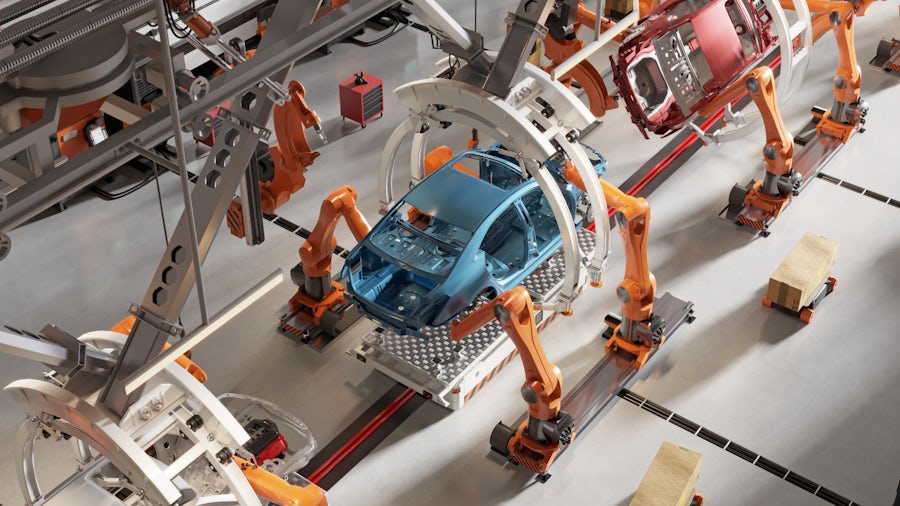 overhead view of a vehicle assembly line where robotic arms are building the vehicle frame