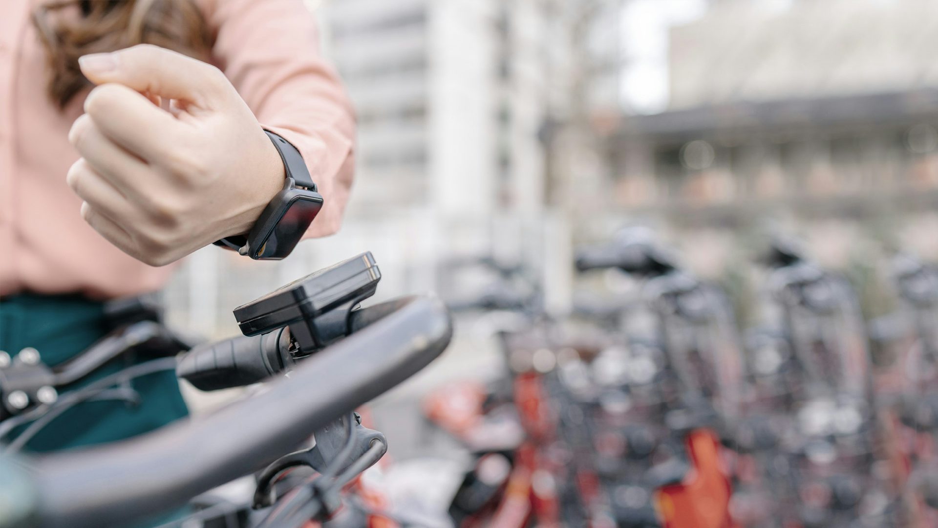 Person with a smart watch holds it to a reader on a bike