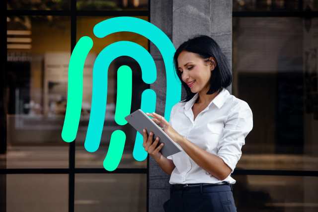Key visual for BACnet Secure Connect showing a person using a tablet in front of a modern building, with a large fingerprint graphic representing secure building automation.
