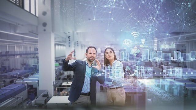 Man and woman with digital representation of industrial automation in a factory.