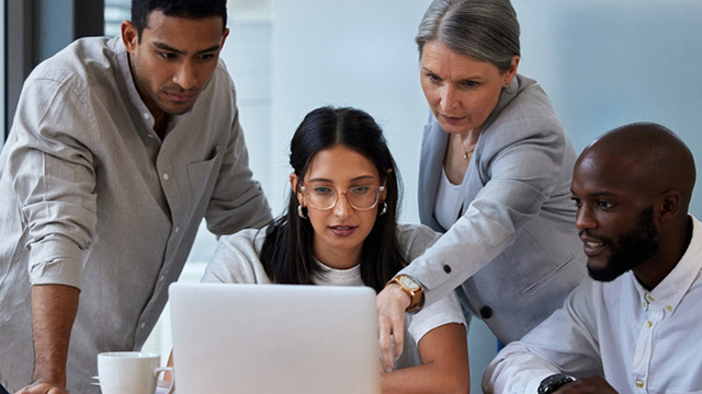 Men and women looking at a laptop computer screen.