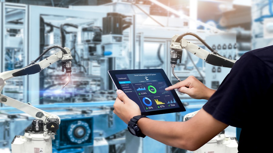 An engineer observing performance analytics for a piece of machinery they're observing on the shop floor. 