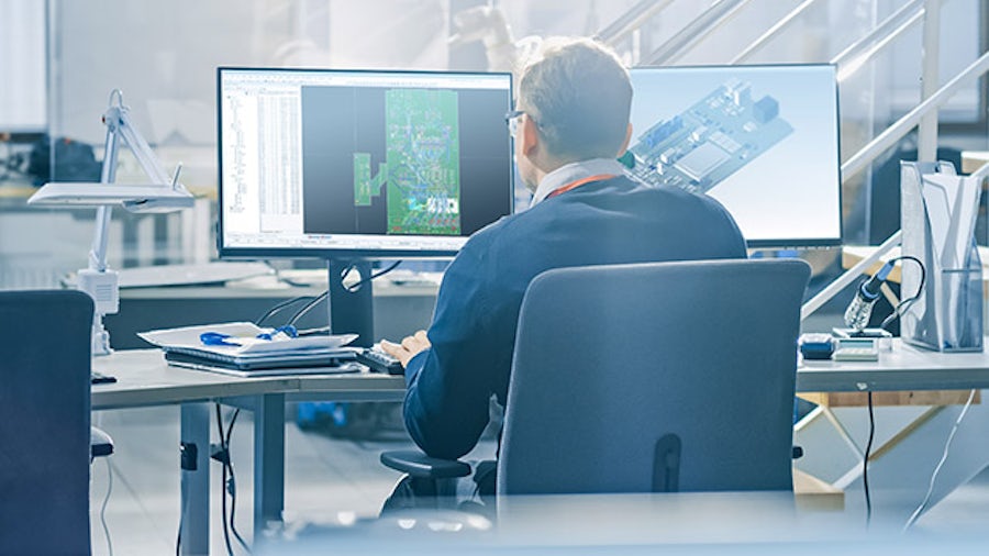 Man sitting behind monitors