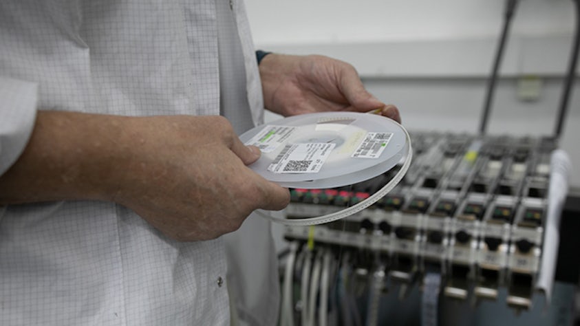 Un responsabile della logistica intra-impianto che osserva un disco in una fabbrica.