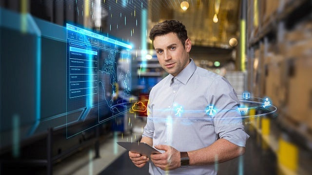 An engineer at a startup holding a tablet working on iIoT solutions. By joining the Siemens startup program, the engineer is able to access many different startup solutions, such as a free trial of MindSphere. 