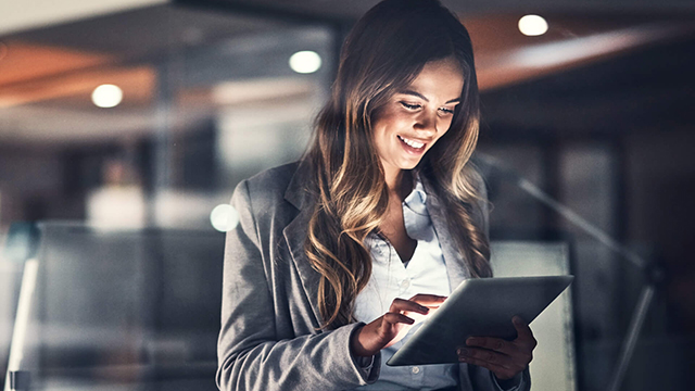 一名女企业家在晚上使用平板电脑。