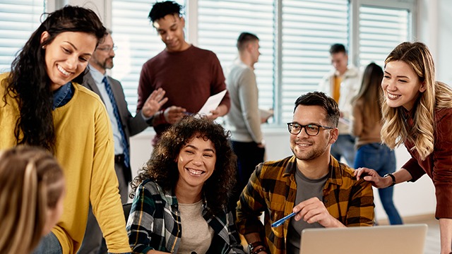 Group of students of various ethnicities and genders discussing engineering around a table.