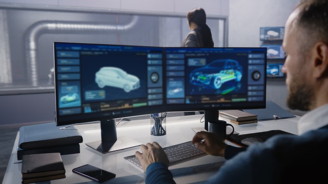 man working on computer with automotive design on screens
