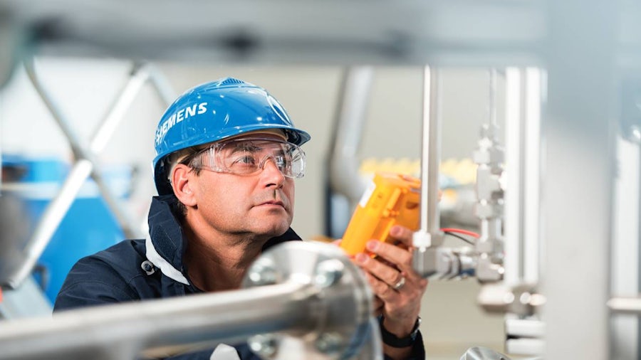 An engineer inspecting industrial equipment in a hydrogen plant. 