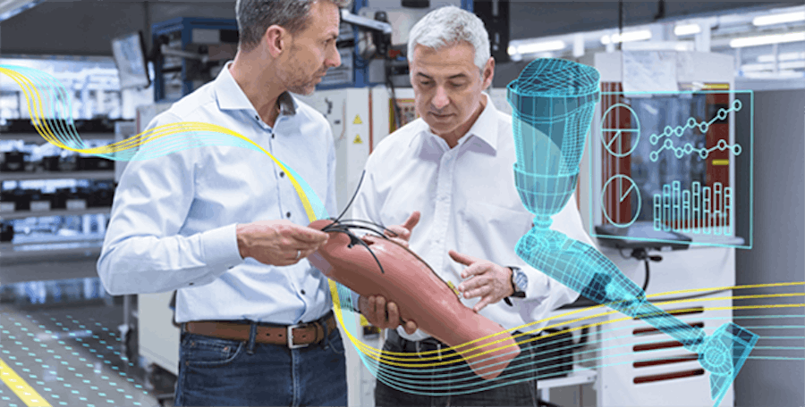 Two, white male designers holding a prosthetic leg and analyzing its design and function.