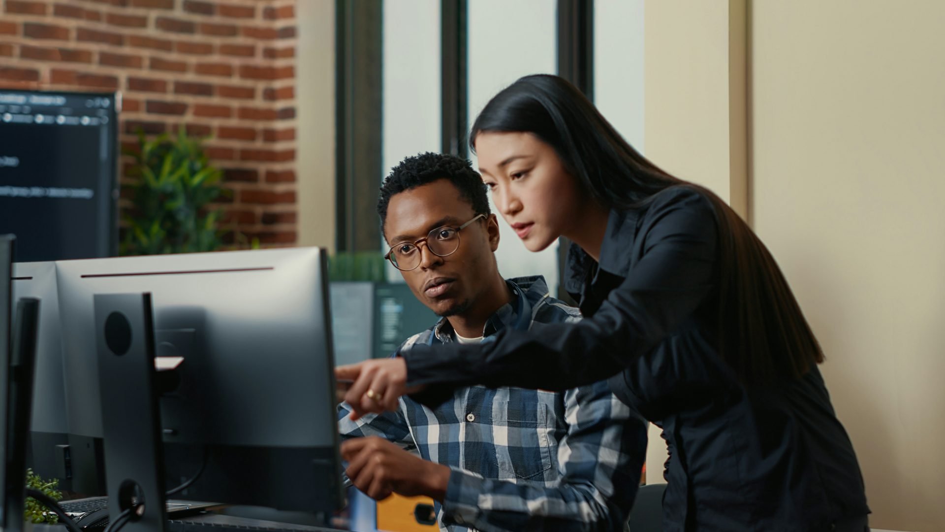 Two engineers working together on a computer.