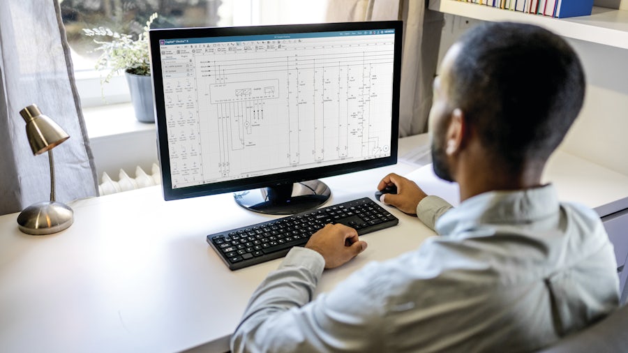 Man at a computer looking at a wiring diagram on the monitor.