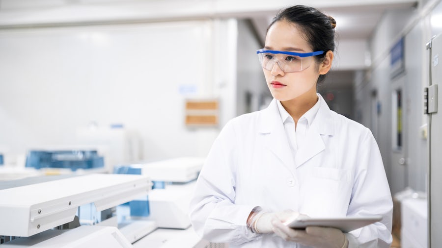 Woman holding a tablet and wearing protective eye gear