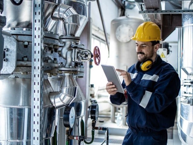 Engineer in a power plant working on a tablet.