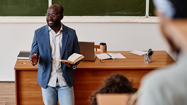 A professor at the front of a classroom giving a lecture.