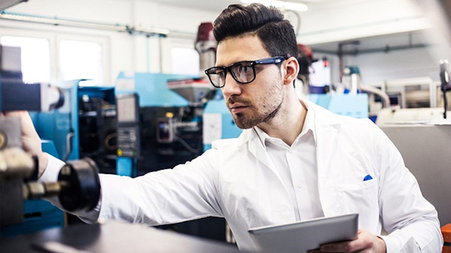 Man with a lab coat working in a manufacturing environment