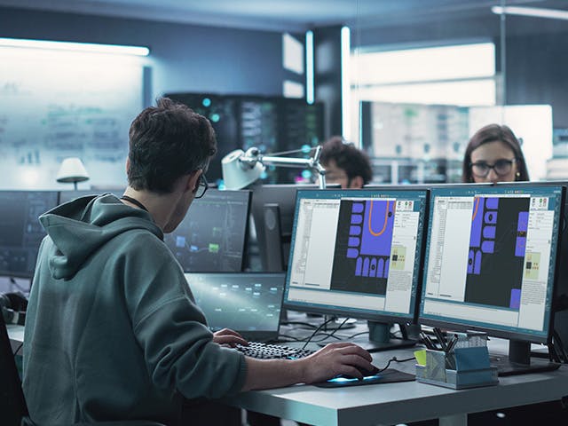 Engineer looking at two screens with Valor NPI DFM analysis