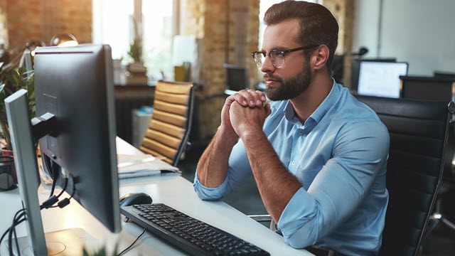 man sitting in front of monitor in an office setting