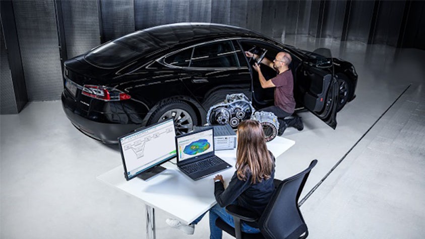 Two people using system noise, vibration and harshness (NVH) performance prediction software on a car.