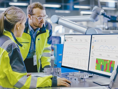 Due ingegneri al lavoro su un computer in una fabbrica analizzano i dati dell'Internet of Things (IoT) industriale raccolti da Insights Hub.