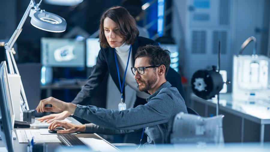 Two engineers looking at a computer conducting design control for medical devices.