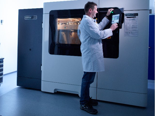 An operator working with an additive manufacturing machine.