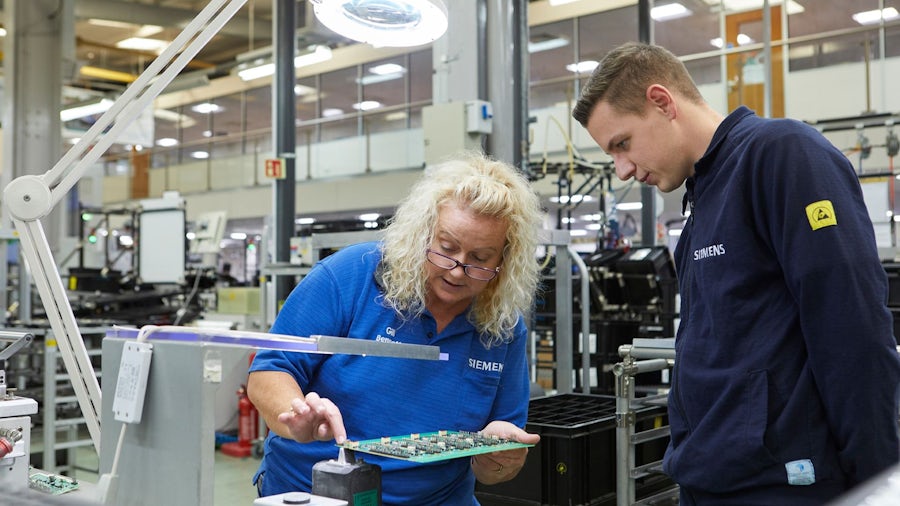 PCB engineer viewing a design on a computer screen on the electronics manufacturing shop floor