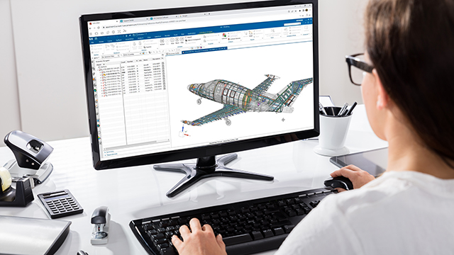 A woman in a yellow sweater is using a laptop. Schematic of an aeroplane in NX on monitor screen.