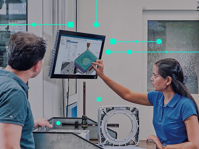 A man looking at the computer screen. he is looking at NX manufacturing on his screen.