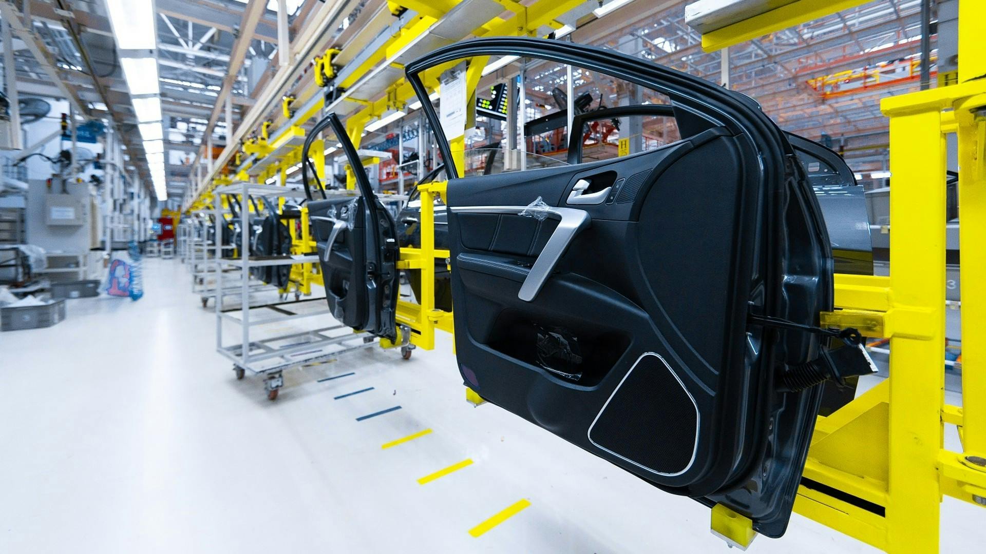 An automated assembly line moving multiple car doors at an automotive manufacturing plant.