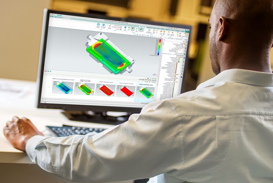 Electronics design engineer sitting at a desk and viewing simulation design software on a computer screen