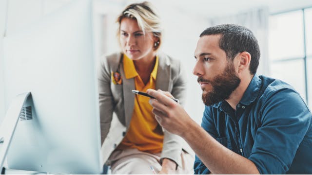 Teammitglieder, die gemeinsam an einem Computer arbeiten.