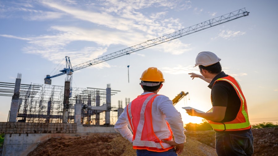 Civil engineers on construction site discussing infrastructure plans.