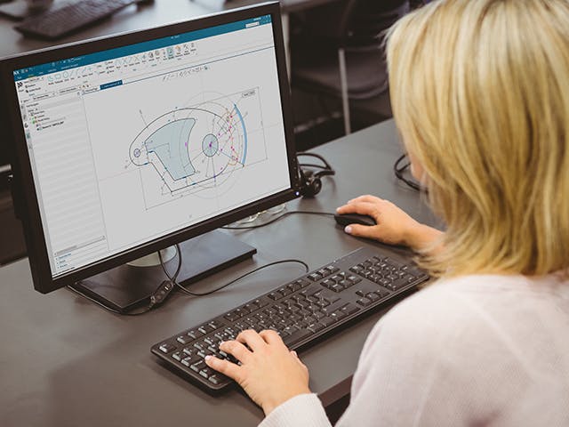 Person at a computer using CAD software on the screen.