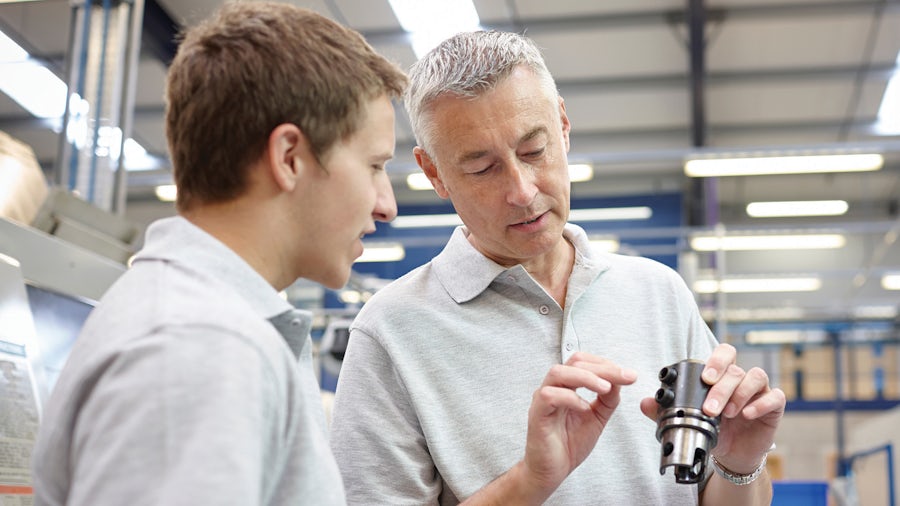 Dos ingenieros inspeccionan un componente de una máquina industrial