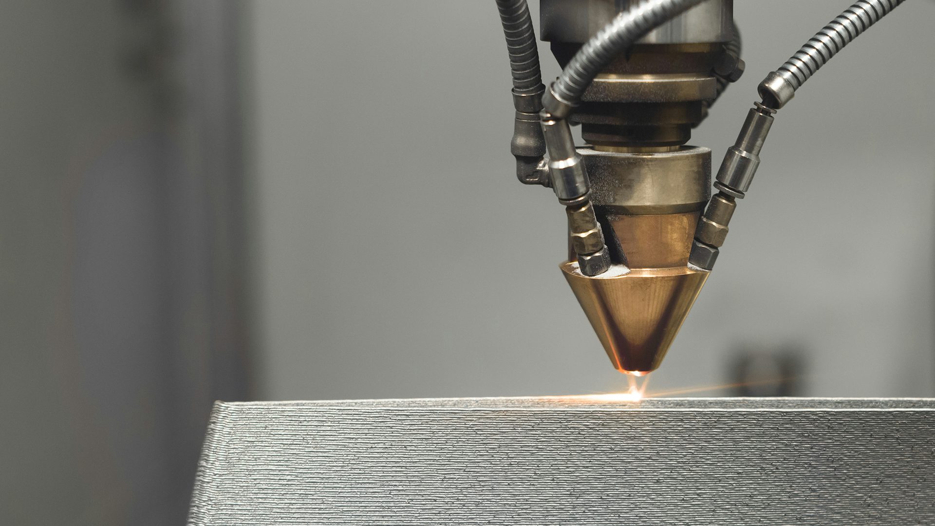 Additive manufacturing machine adding a layer to a component