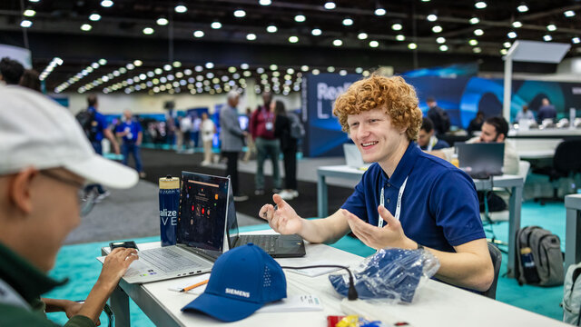 Two students sitting at a desk looking at their computers.