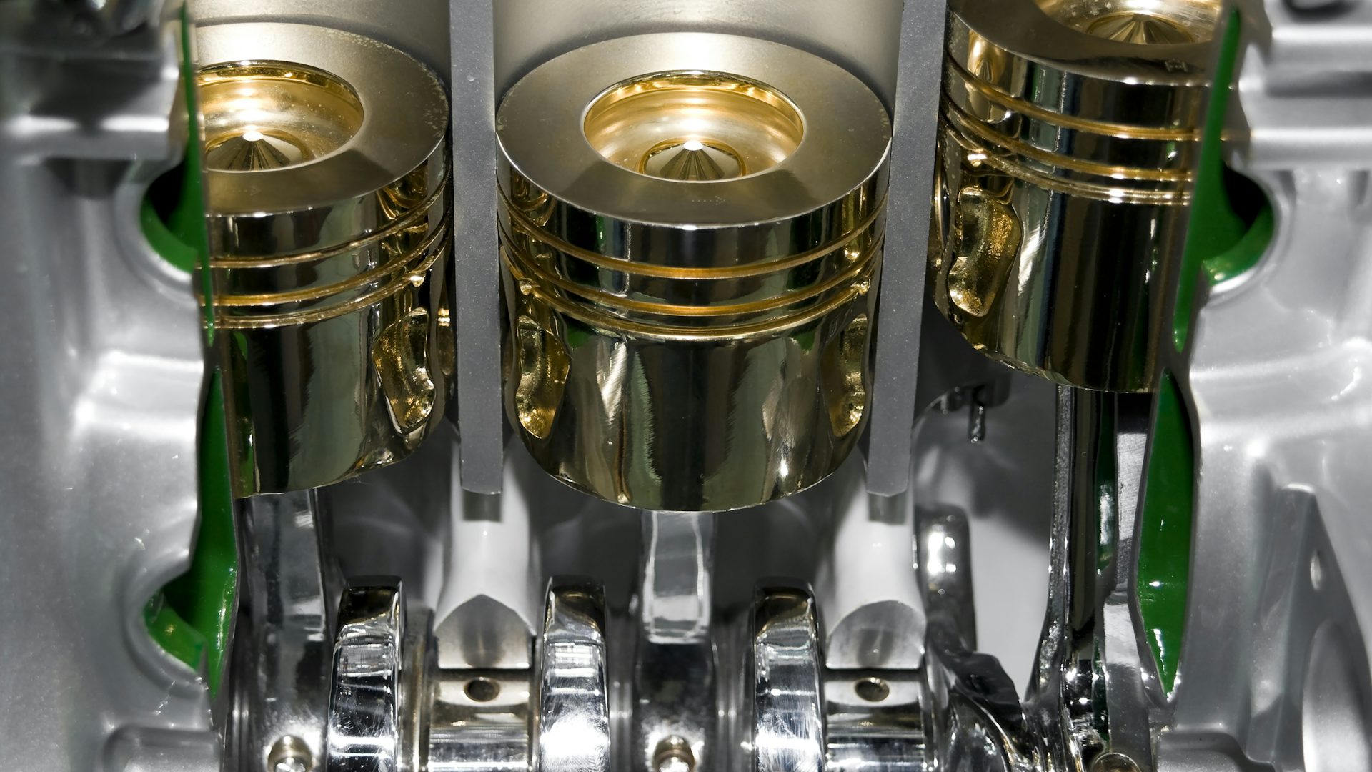 Un bloc-cylindres automobile de couleur or et un piston de voiture. Ce piston peut être conçu pour la simulation du système de propulsion de Simcenter.