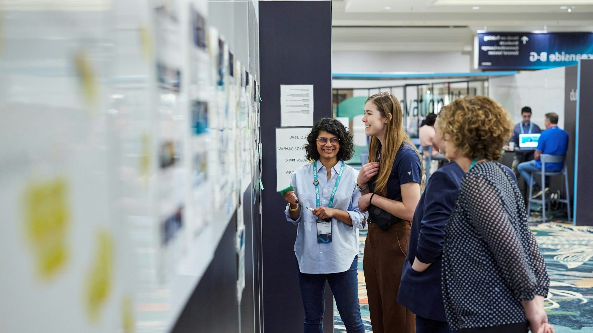 Customers standing and looking at Innovation hub research projects.