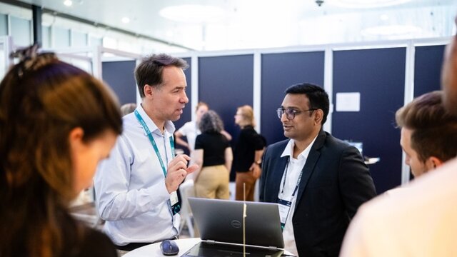 Customers standing and looking at Innovation hub research projects.