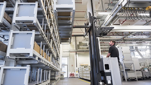 A lift operator uses a warehouse management system to organize warehouse inventory rows.