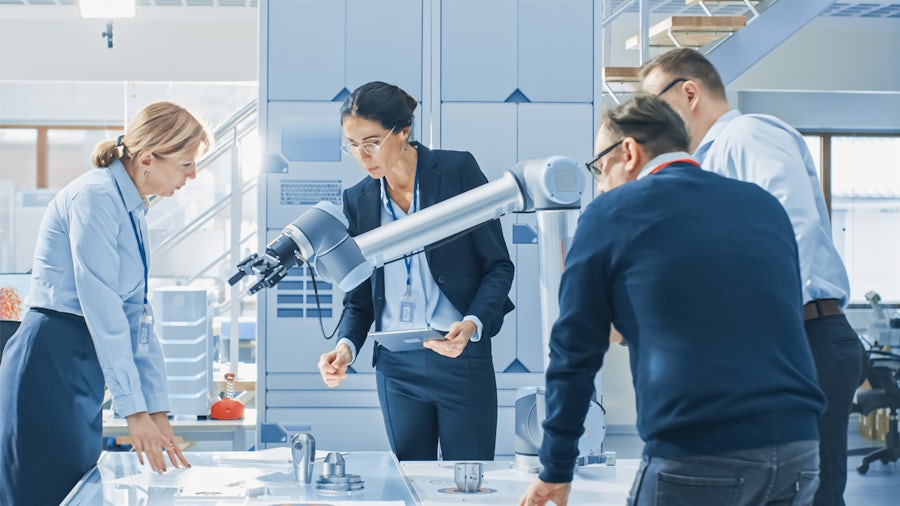 Four workers and a robotic arm in an office building.