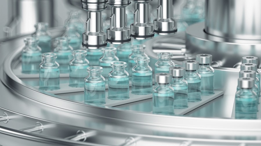 Automated pharmaceutical manufacturing line filling and sealing vials with blue liquid.