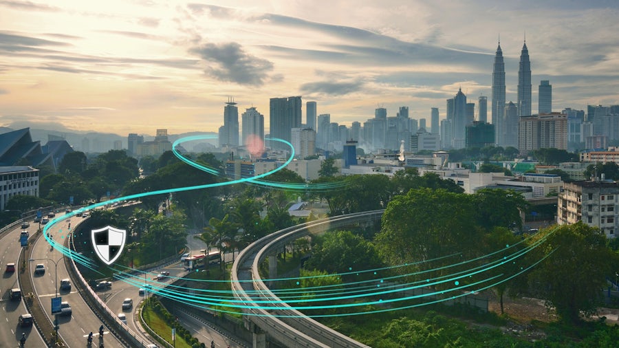Interstate highway with cars driving that leads towards a major city. Green illustration along the length of the highway showing the logistic connection in transportation. 