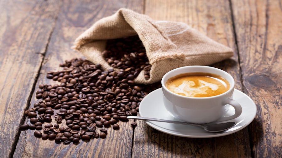 Coffee cup and coffee beans on a table.