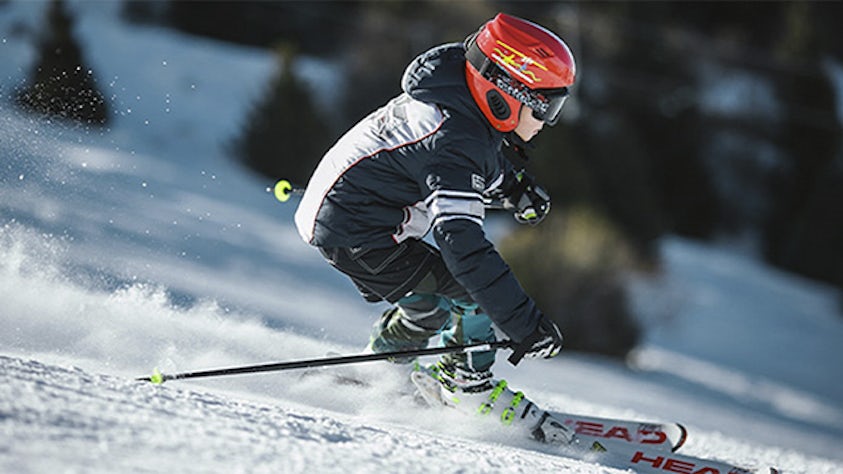 A man wearing skiing gear skiing.