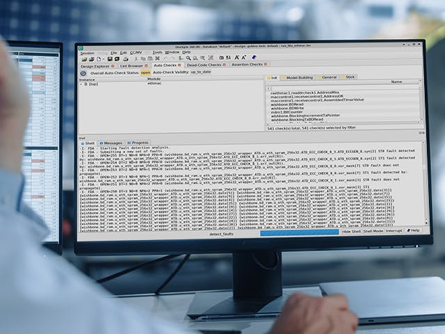 Engineer thinking in front of two monitors showing Questa Analyze Fault
