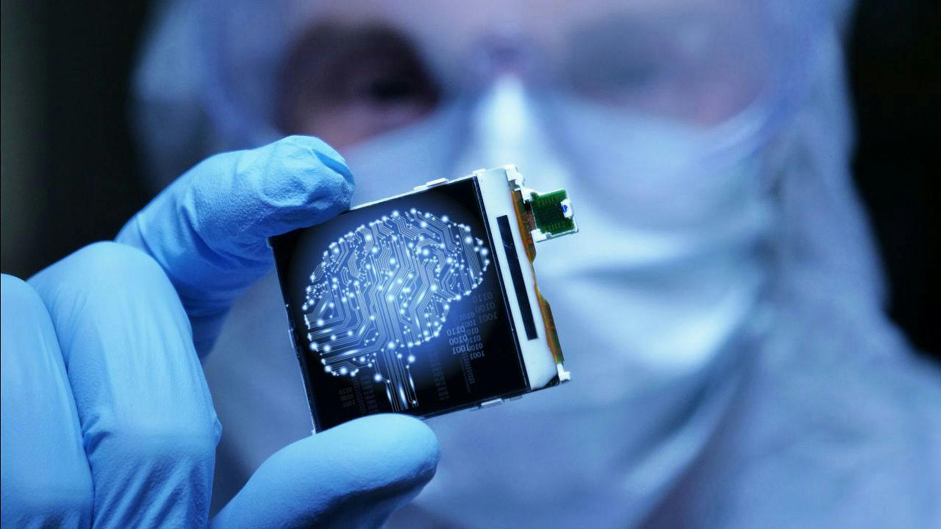 A person holding a small computer chip between their fingers and performing smart manufacturing 