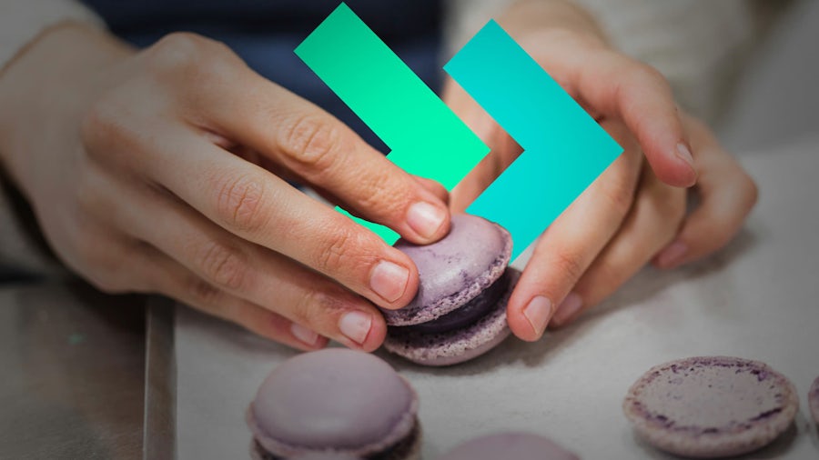 Person touching macaroons.