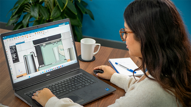 Una donna si siede a un laptop, guardando una dashboard in NX